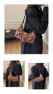 Vue détaillée du sac porté épaule vintage marron avec boucle argentée et texture de cuir plissé