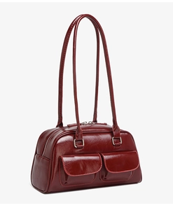 Detailed view of dark red oil wax leather handbag with dual front pockets and top zip