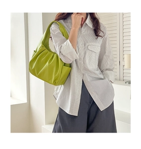 Detail of light green pleated shoulder bag featuring soft textured synthetic leather