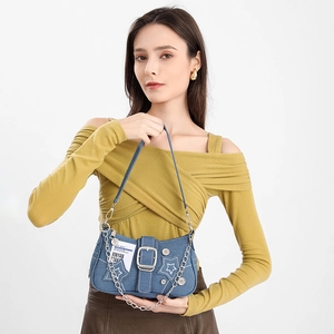 Detail of denim star shoulder bag with silver chain and metal button accents