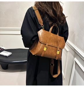 Detail of vintage brown leather backpack with retro metal buckles and flap design