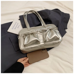Silver metallic tote bag detail showing dual front pockets with bow ties and spacious interior