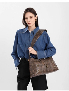 Detailed view of the vintage leather tote with bronze buckles and wide shoulder strap