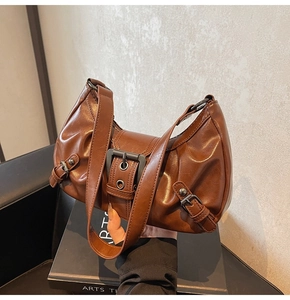 Détail du sac sous le bras en similicuir marron vintage avec grande boucle métallique
