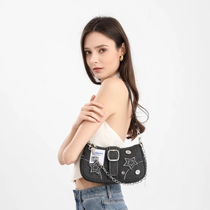 Detail of black denim shoulder bag featuring white star embroidery and silver metal chain