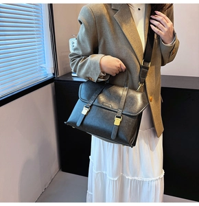 Detail of grey vintage leather handbag with gold hardware and wide shoulder strap