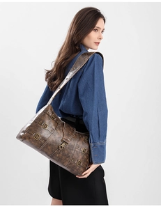 Detailed view of vintage brown punk tote with heavy metal rivets on model's shoulder
