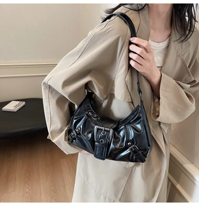 Détail du sac à bandoulière noir plissé avec boucle et garnitures argentées sur modèle