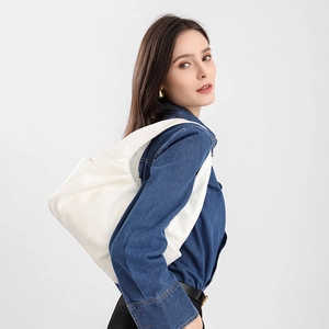 White pleated leather hobo bag styled as a large shoulder bag on a female model