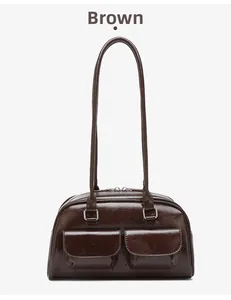 Detail of a dark brown oil wax leather bowling bag with pockets and long straps