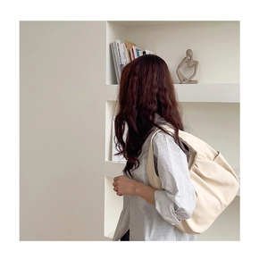 Detail showing the creamy white soft leather texture and pleated design of the cloud bag