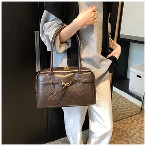 Gros plan du sac porté épaule marron vintage avec boucle dorée et texture de fermeture