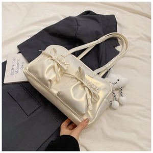 Detail of pearlescent white tote bag with bow-knot pockets and cute cloud pendant charm