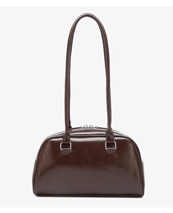 Detailed view of the dark brown oil-wax leather texture and silver hardware of the bowling bag