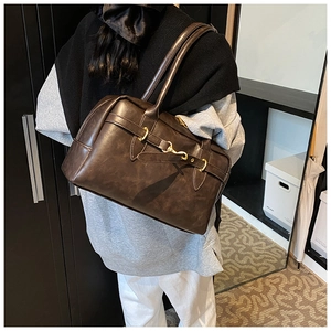 Détail du sac Boston vintage marron foncé avec boucle fer à cheval et longue bandoulière