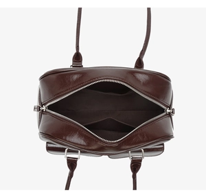 Deep coffee oiled leather bowling bag showing internal zipper pocket and storage compartments