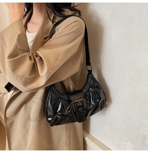 Détail du sac porté épaule en cuir verni noir avec boucle métallique et fini rétro