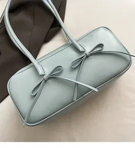 Détail du sac Boston bleu menthe avec nœuds et texture en cuir plissé élégant