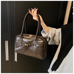 Détail de sac Boston vintage marron foncé avec sangle en cuir et boucle métallique chic