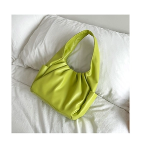 Detail shot of neon green pleated cloud bag in textured PU leather with wide strap