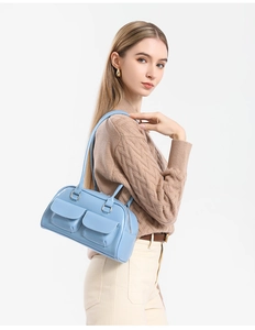 Close-up of light blue oil wax leather shoulder bag with double front flap pockets