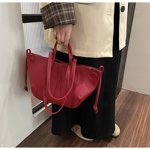 Side view of dark red lychee leather tote bag with side drawstring details for women