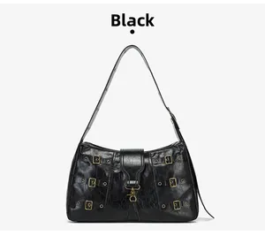Detailed view of black retro tote bag with bronze metal buckles and worn leather texture
