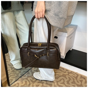 Vue détaillée du sac Boston vintage marron foncé avec fermetures éclair dorées et longue anse