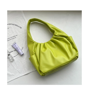 Detailed close-up of bright green ruched leather texture on a stylish croissant bag