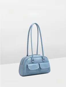 Detail of light blue oil wax leather bowling bag featuring double front flap pockets and zippers