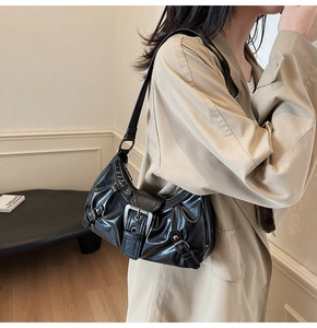 Détail d'un sac cabas vintage en cuir froissé noir avec une boucle en métal argenté