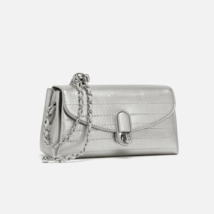 Dettaglio della borsa in pelle metallizzata argento con chiusura a rotazione ovale
