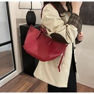 Detail of dark red lychee leather tote with white contrast stitching and side lace