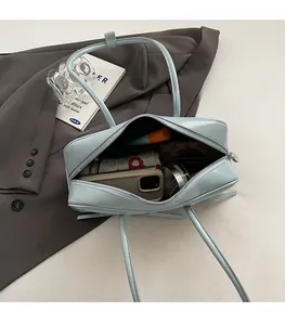 Intérieur spacieux du sac Boston bleu clair montrant le rangement pour téléphone et maquillage