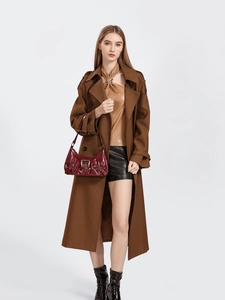 Fashionable burgundy glossy handbag paired with a long brown wool coat and leather boots