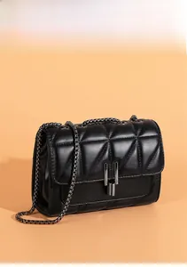 Detailed side view of black quilted crossbody bag with metal chain and buckle