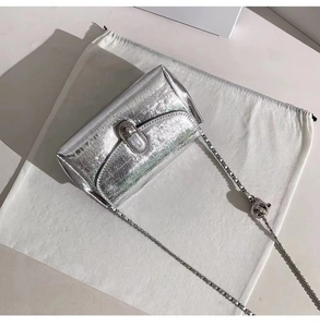 Dettaglio macro della fibbia a testa di serpente argento e catena di una borsa