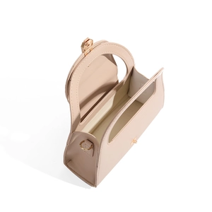 Interior view showing capacity and gold hardware of the beige half-round crossbody bag