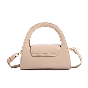 Macro shot of minimalist beige semi-round handbag with textured PU leather and gold buckle
