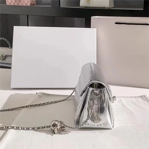 Dettaglio della borsa a tracolla argento metallizzato con catena e ciondolo