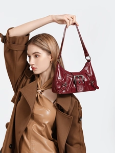 Close-up of wine red Y2K retro shoulder bag featuring metallic buckles and glossy leather