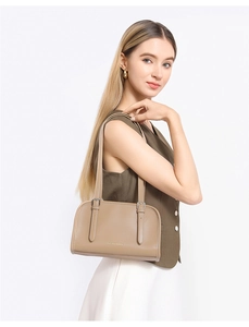 Detail showing khaki faux leather shoulder bag with slim straps on female model
