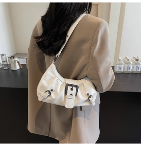 Détail d'un sac sous les aisselles en cuir PU blanc brillant avec boucle noire et plis