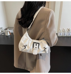 Gros plan d'un sac hobo blanc brillant avec boucles en métal noir et détails plissés