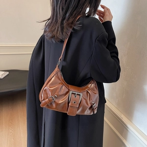Détail du sac à bandoulière marron plissé en demi-lune avec boucle en métal vintage