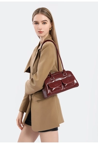 Detail of burgundy oil wax leather shoulder bag featuring glossy finish and dual front pockets