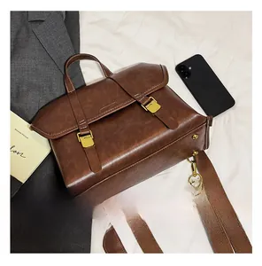 Detail view of the brown leather backpack with retro gold buckles on a white background