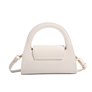 Macro view of cream white mini crossbody bag with a large semi-circle handle and gold buckle