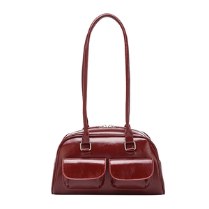 Vintage burgundy oiled leather bowling bag with long shoulder straps and front pockets
