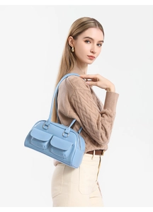 Close-up of light blue oil wax leather handbag with silver buckles and flap pockets